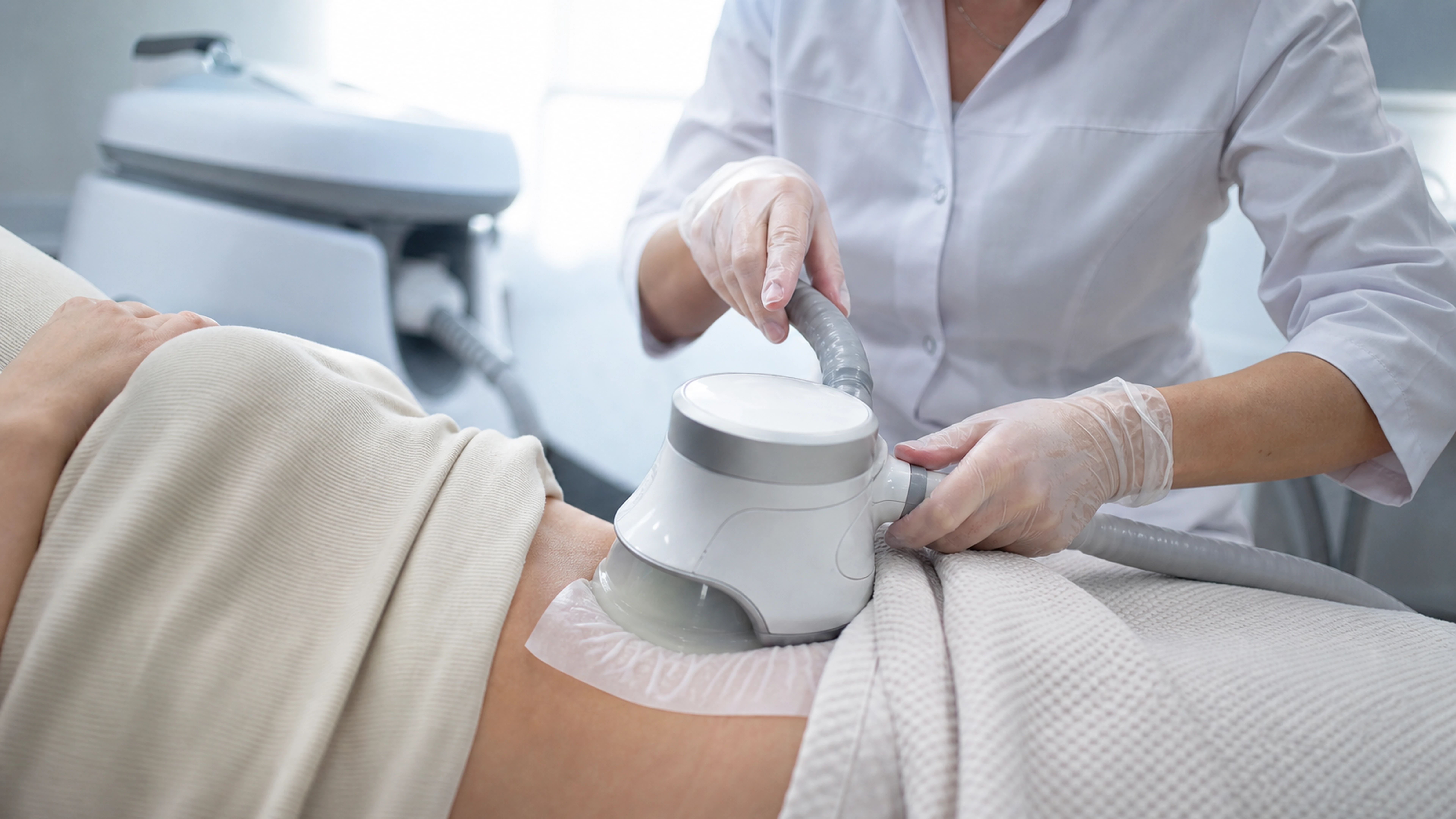 Séance de cryolipolyse avec applicateur posé sur le bas-ventre